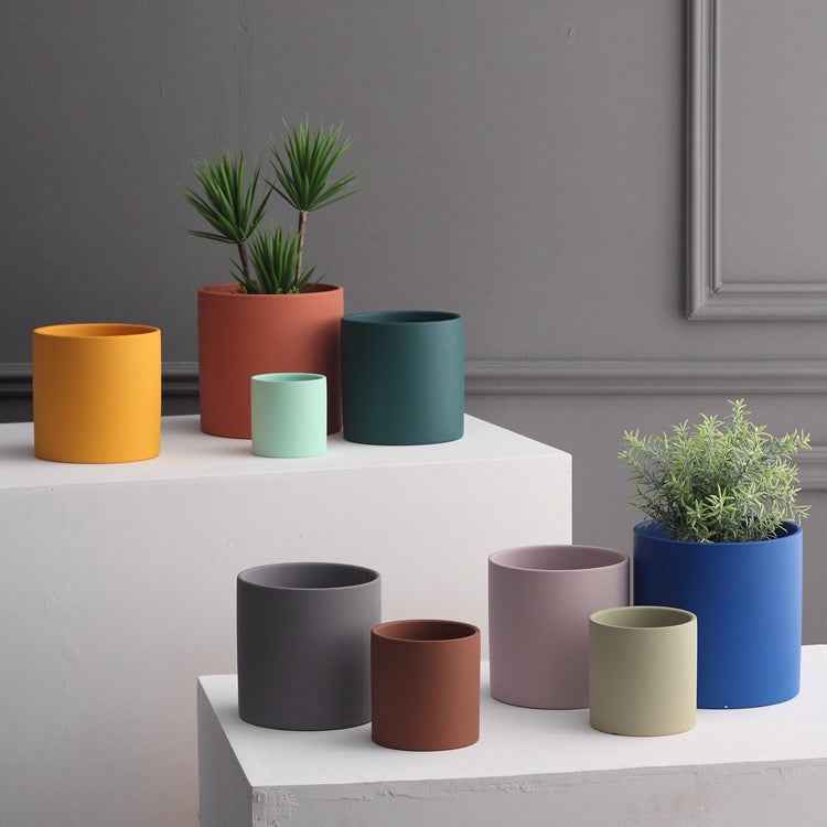 Farbiger, zylindrischer Pflanzgefäß-Set aus mattem Material, ideal für Pflanzen und Dekorationen im Garten oder Zuhause.